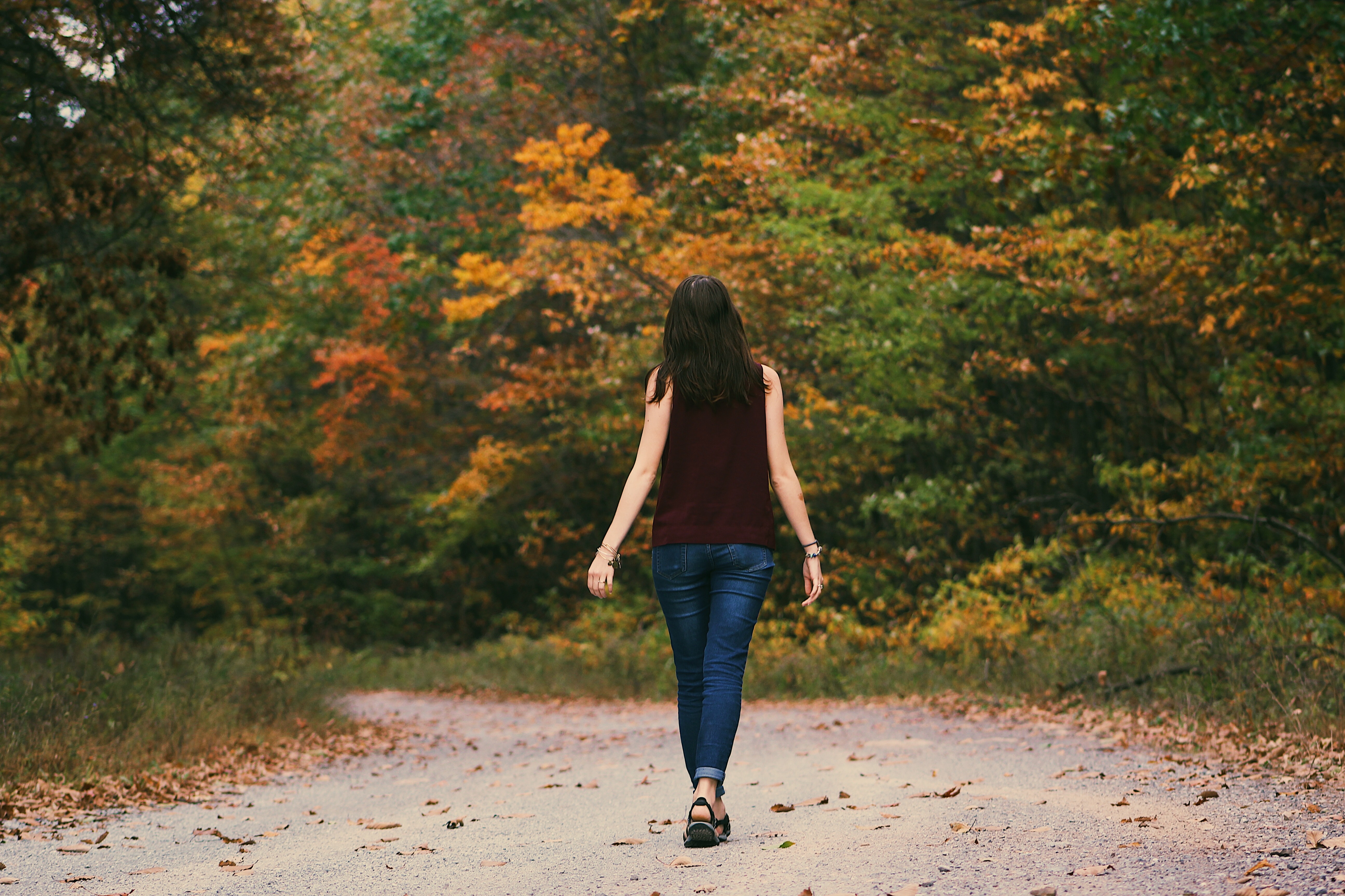 Femme de dos marchant sur un chemin dans la nature dans l'écoute de son environnement