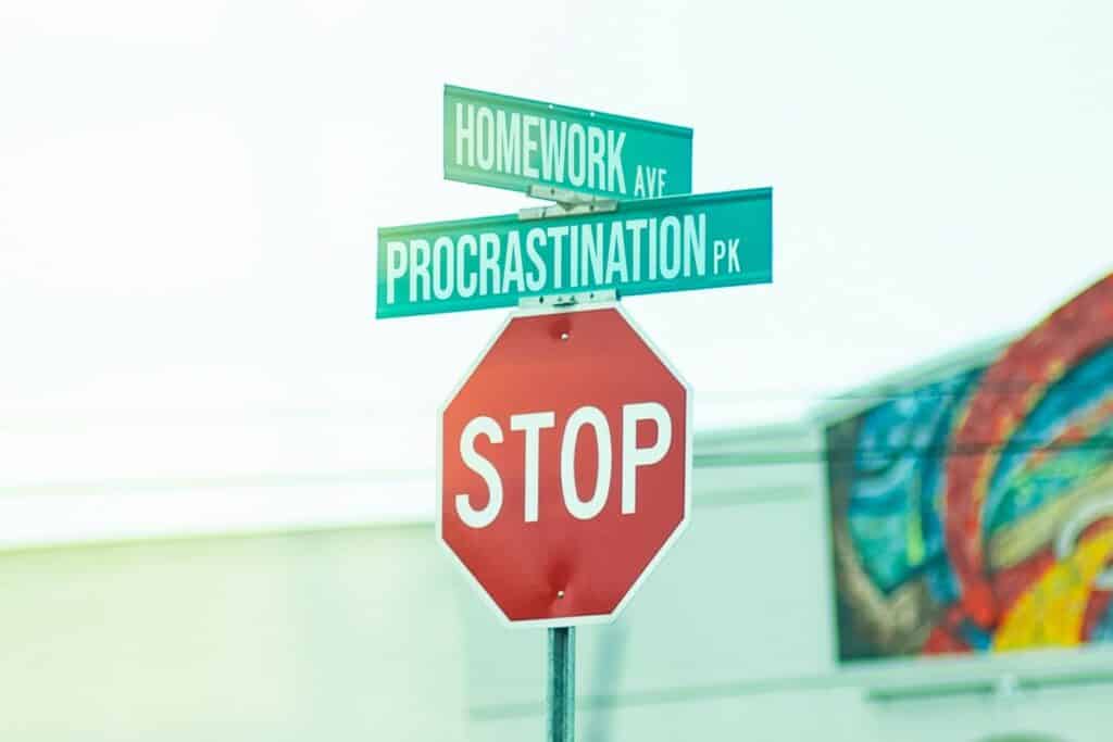 Un panneau stop avec une rue nommée procrastination et l'autre homework